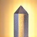 Clear quartz point standing upright, surrounded by meditating hands and soft, diffused light, symbolizing spiritual connection.