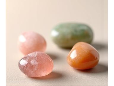 A variety of tumbled rose quartz, aventurine, and carnelian crystals arranged aesthetically, symbolizing emotional balance and calm.